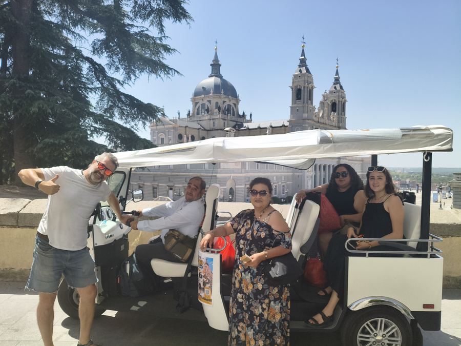 Group of five on a sunny Tuk Tuk tour near the Almudena Cathedral, Madrid