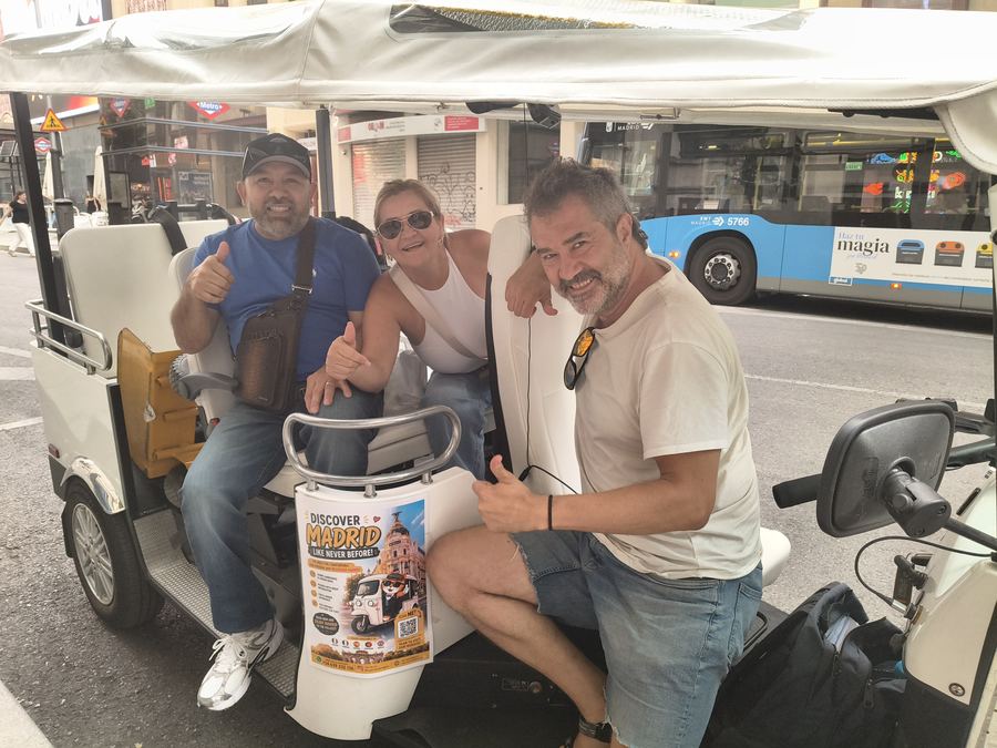 Friends on a Tuk Tuk tour on a street in central Madrid