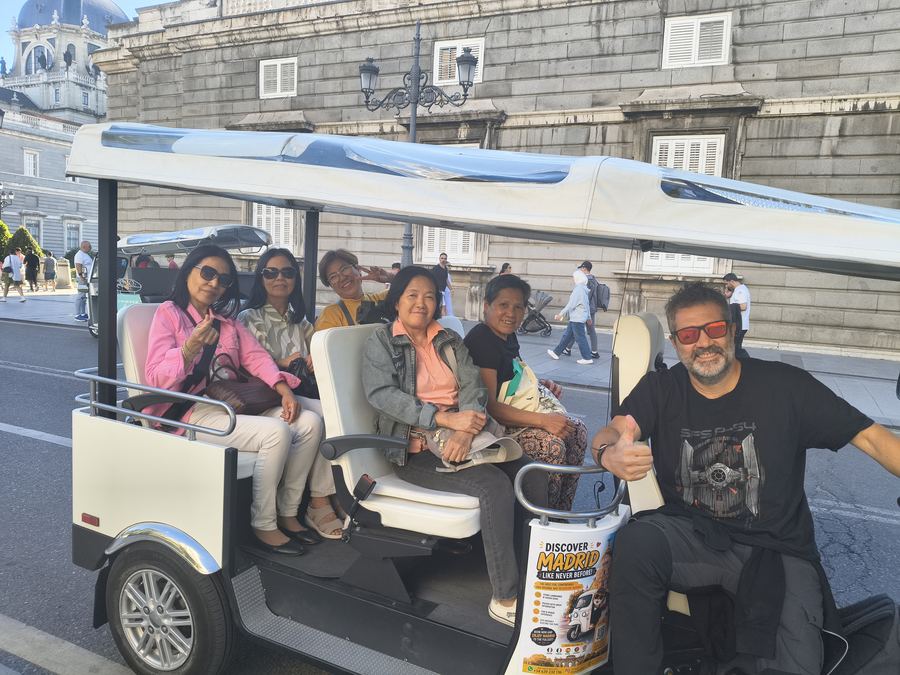 Group of friends on a Tuk Tuk tour near the Royal Palace, Madrid