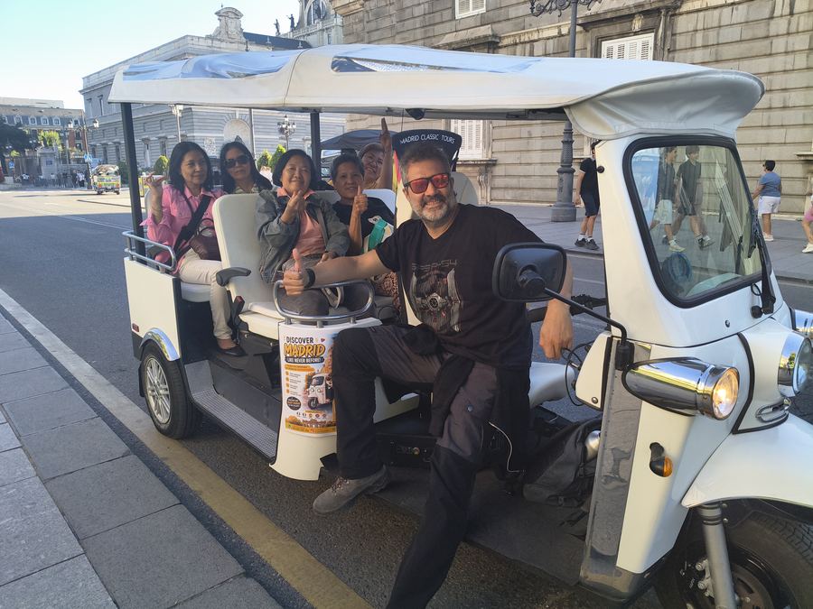 Driver giving a thumbs up with a group of clients near the Royal Palace, Madrid